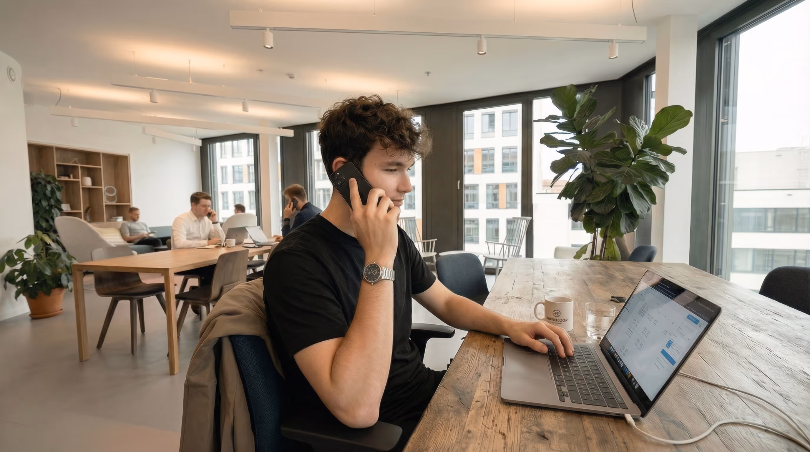 Adrian telefoniert im Office mit einem Kunden